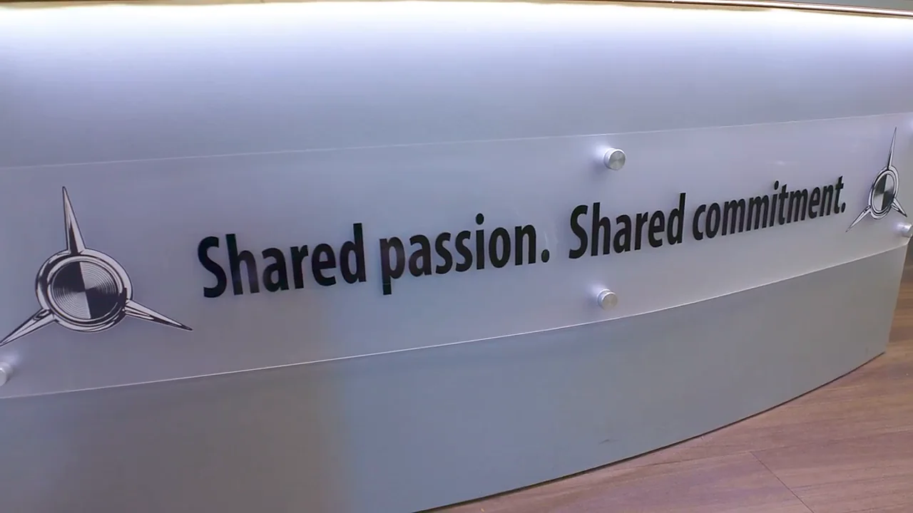 The brushed aluminium front counter at Silver Arrow Service, lettered Shared passion. Shared commitment.